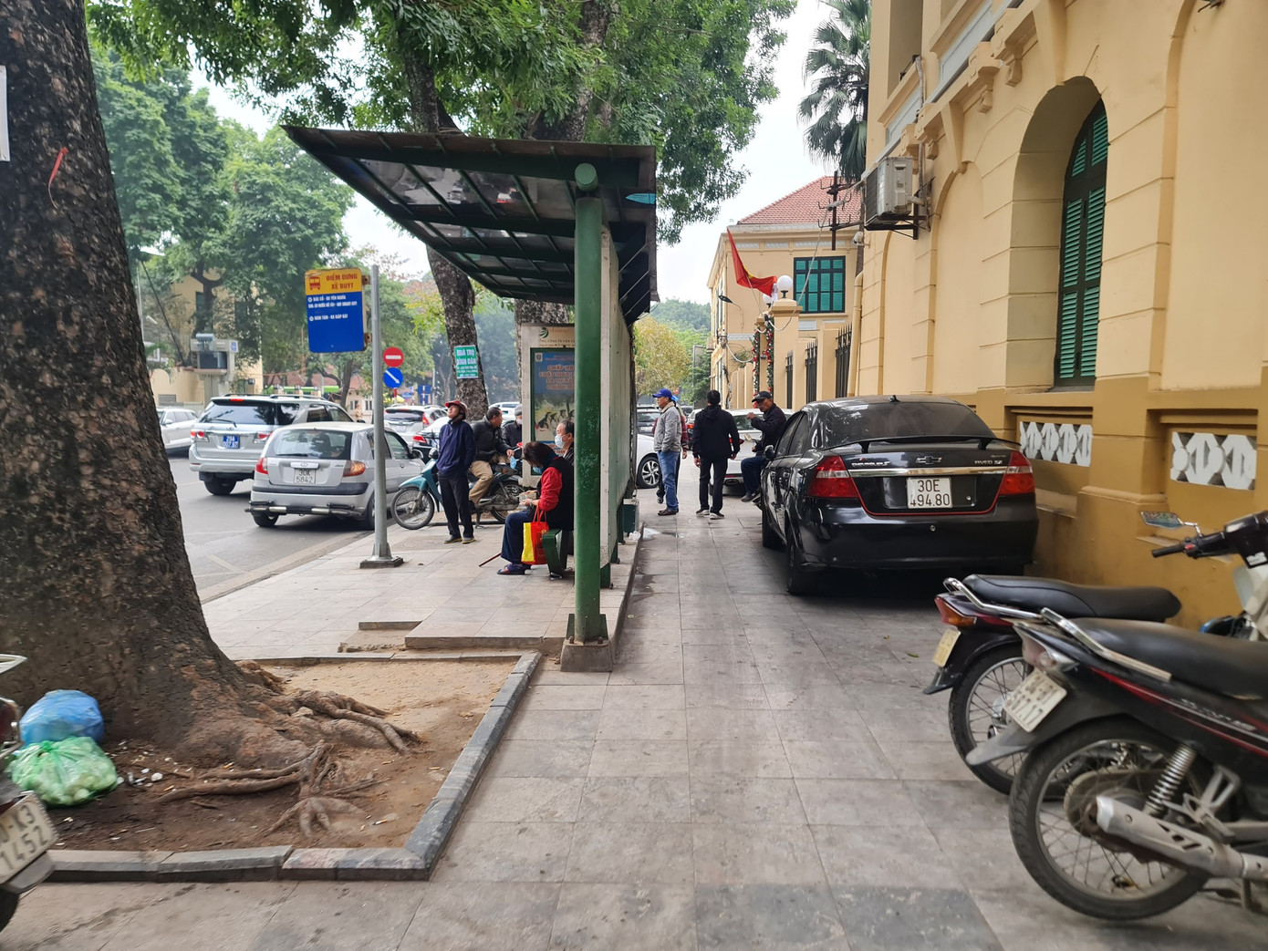 Phía bên cổng bệnh viện, ô tô cũng được xếp vào các chỗ trống trên vỉa hè.