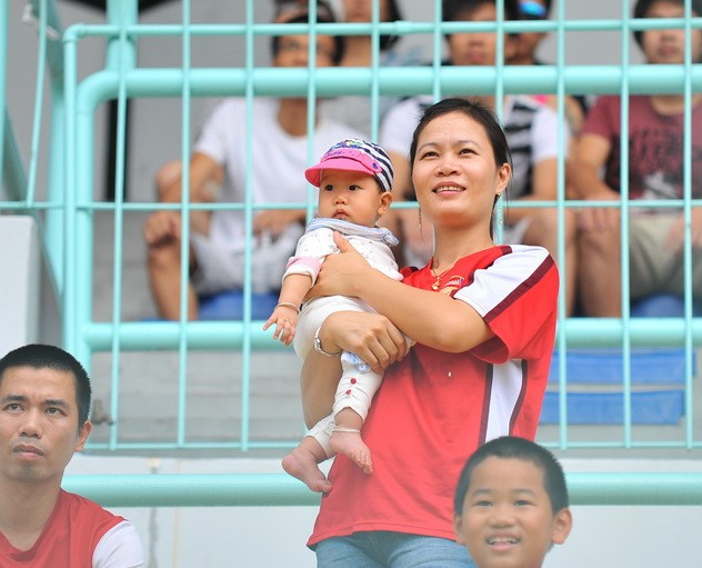 Hai mẹ con CĐV Việt Nam cổ vũ cho các cầu thủ trẻ 