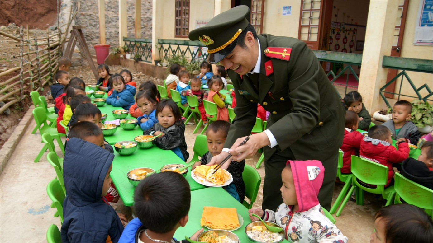 Trung úy Dương Hải Anh bên các em nhỏ tại điểm trường Hin Pén, thuộc Trường Mầm non Phòng Lan, xã Chiềng Sơn, huyện Mộc Châu, Sơn La. Ảnh: Hồng Vĩnh