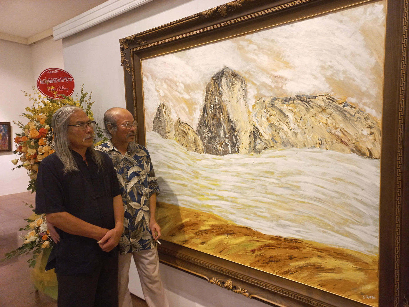 Tác giả bài viết (bìa trái) trước một tác phẩm trong triển lãm