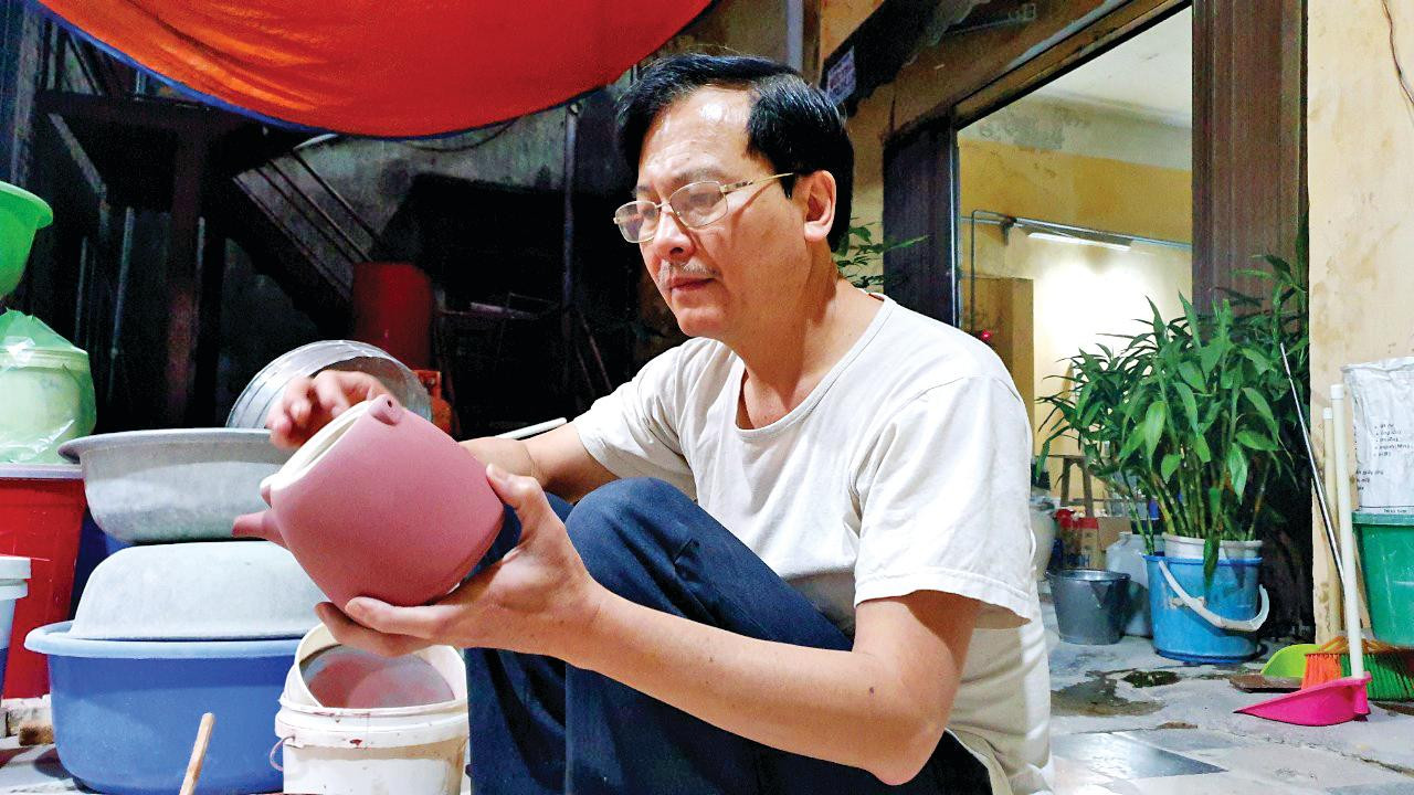 Nghệ nhân Vương Thế Cường đang lên men cho bộ ấm Nhị Hà