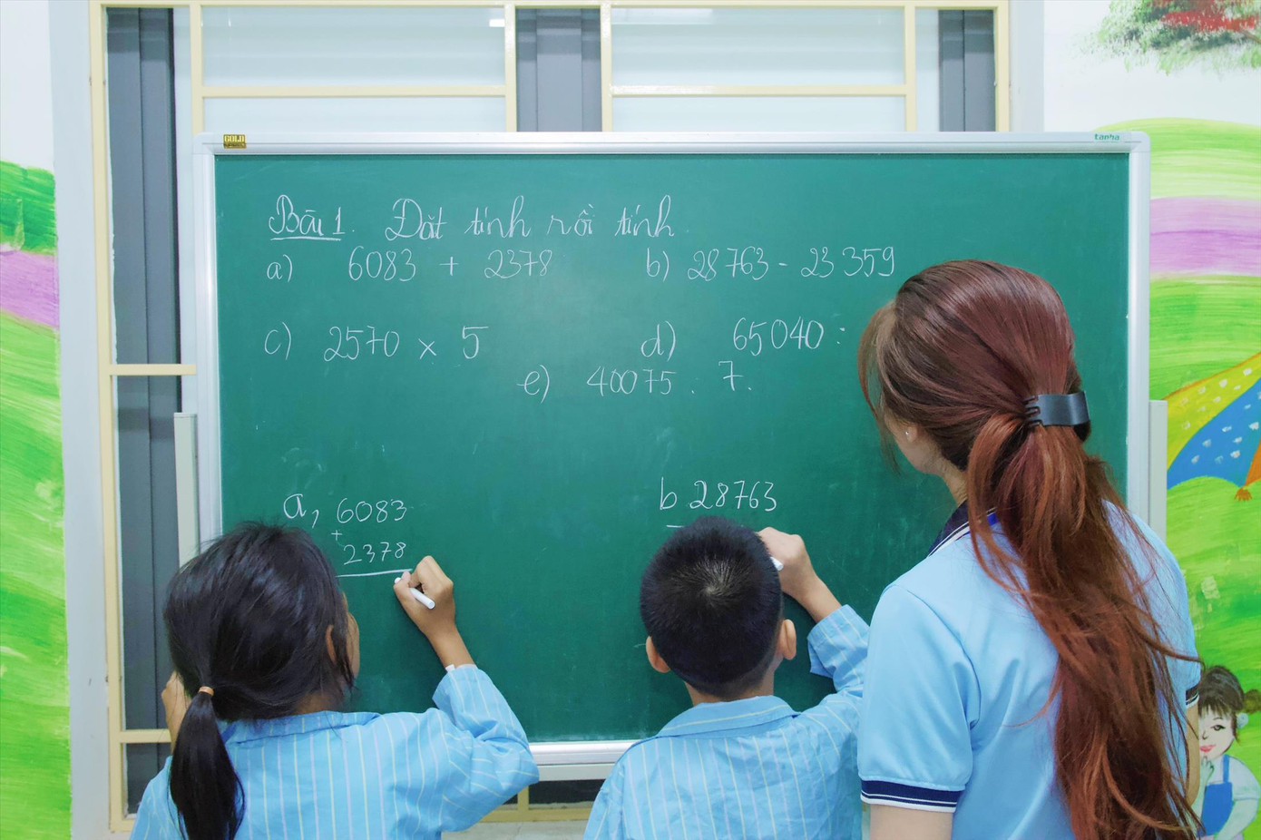 Sinh viên tình nguyện Trường ĐH Vinh hướng dẫn các em nhỏ làm bài