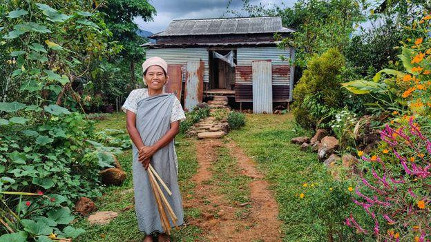 Một người phụ nữ bản địa trước nhà riêng ở Kongthong