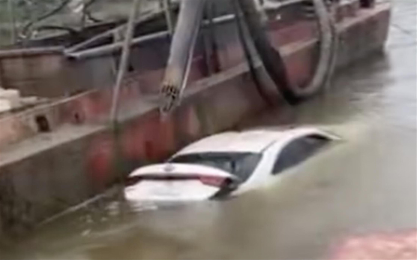 Chiếc xe trôi trên sông Hồng. Ảnh cắt từ clip Chiếc xe trôi trên sông Hồng. Ảnh cắt từ clip