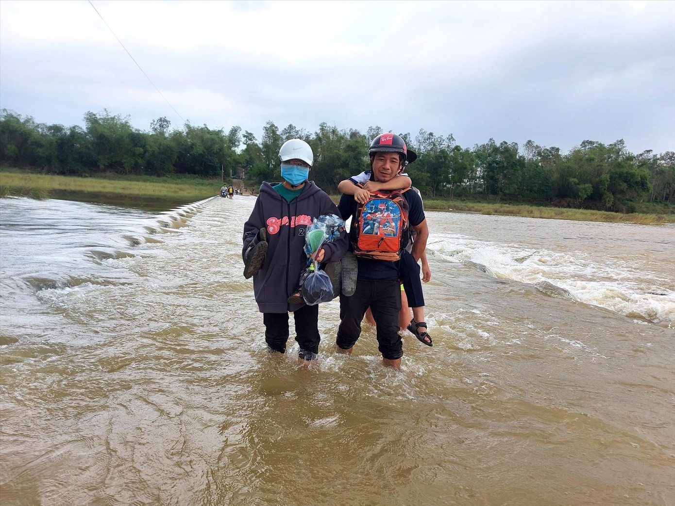 Người dân Lệ Bắc lội nước cõng con đến trường ngày mưa lũ