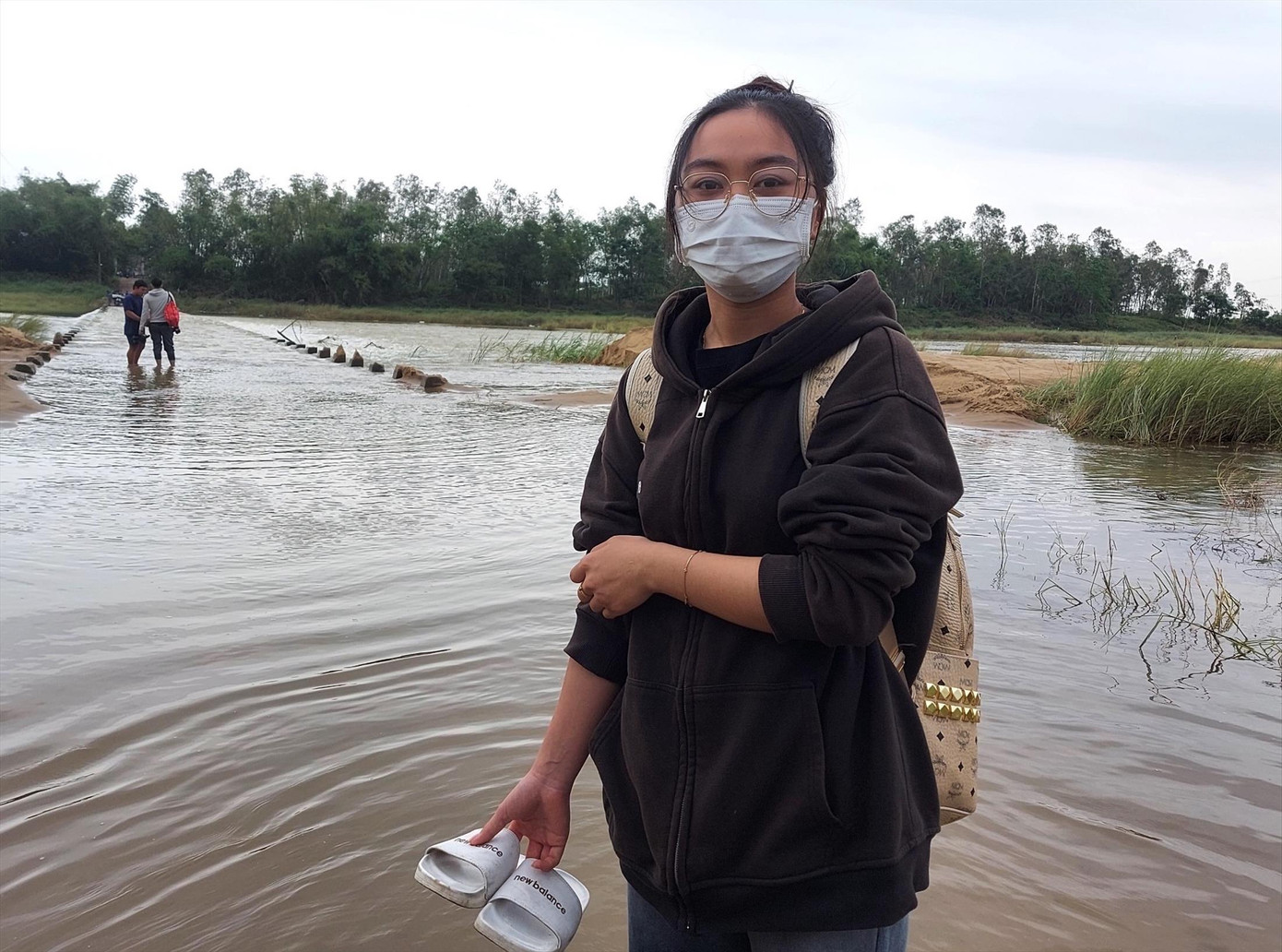 Cô sinh viên Lê Thị Hoài Trinh xách dép lội nước về làng Ảnh: Hoài Văn