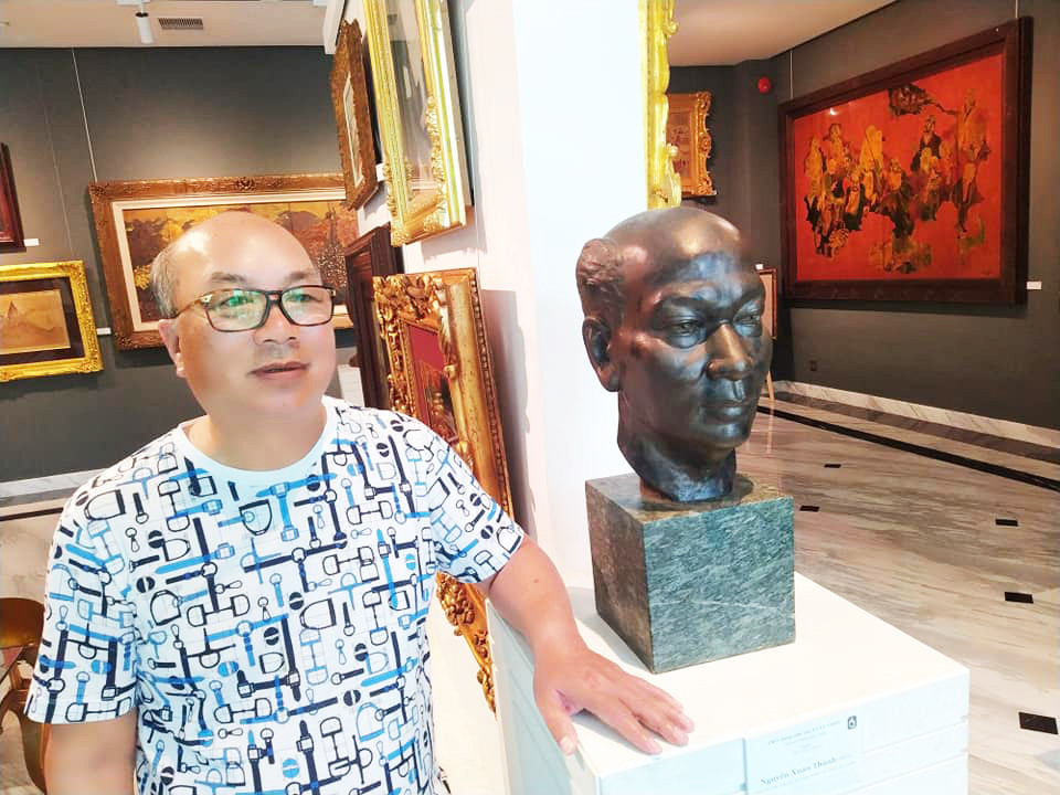 Nhà sưu tập Nguyễn Thiều Quang bên bức tượng bố - Nhà văn Xuân Thiều Ảnh: Trần Nguyên Anh