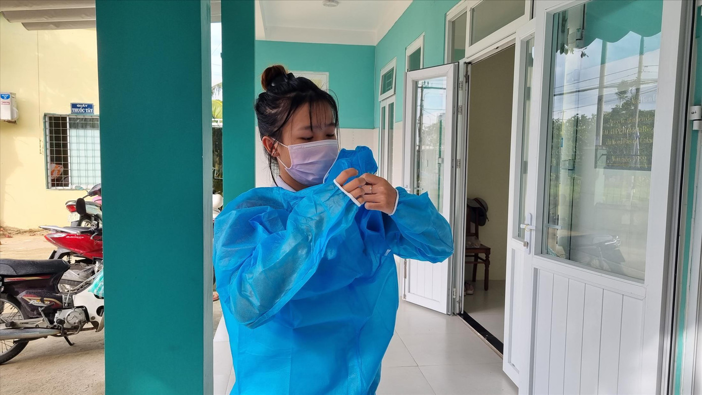 Thái Thị Hoàng Anh mang đồ bảo hộ chuẩn bị lấy mẫu cho người tiếp xúc với F0 tới trạm khai báo. Ảnh: Thanh Trần