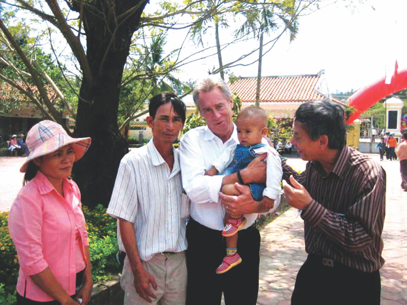 Nhà thơ Thanh Thảo - bên phải - cùng cựu phi công Mỹ L.Coburn bên những em bé Sơn Mỹảnh: Trần Tuấn