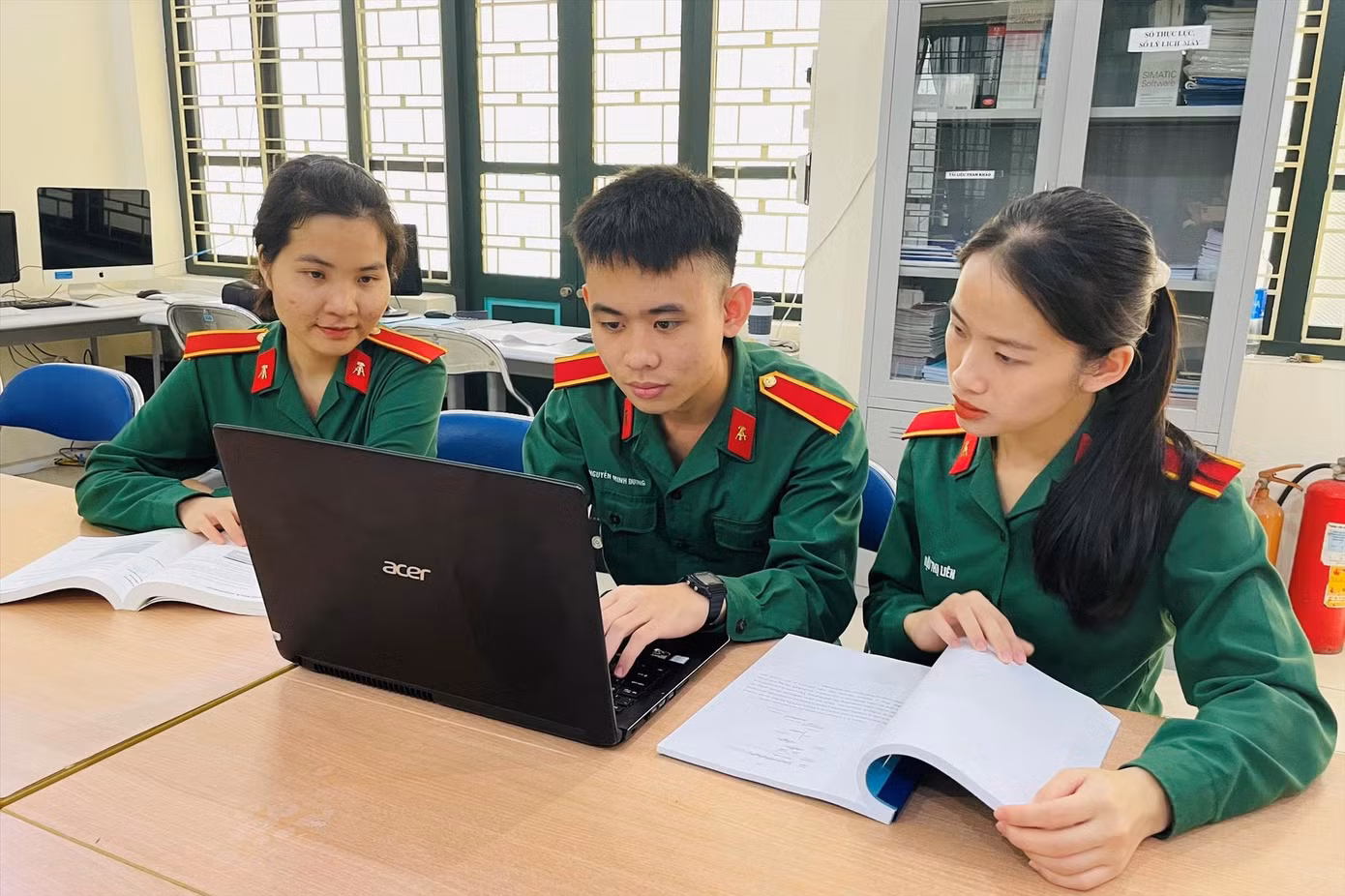 3 học viên Nguyễn Thị Uyên, Nguyễn Minh Dương và Đậu Thị Liên (lần lượt từ trái qua) trao đổi đề tài NCKH tại phòng thí nghiệm