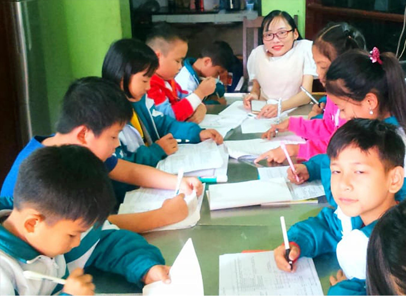 “Chị Tâm” (SN 1990, ở xã Yên Quang, huyện Ý Yên, Nam Định) hướng dẫn các em học bài. Ảnh: NVCC