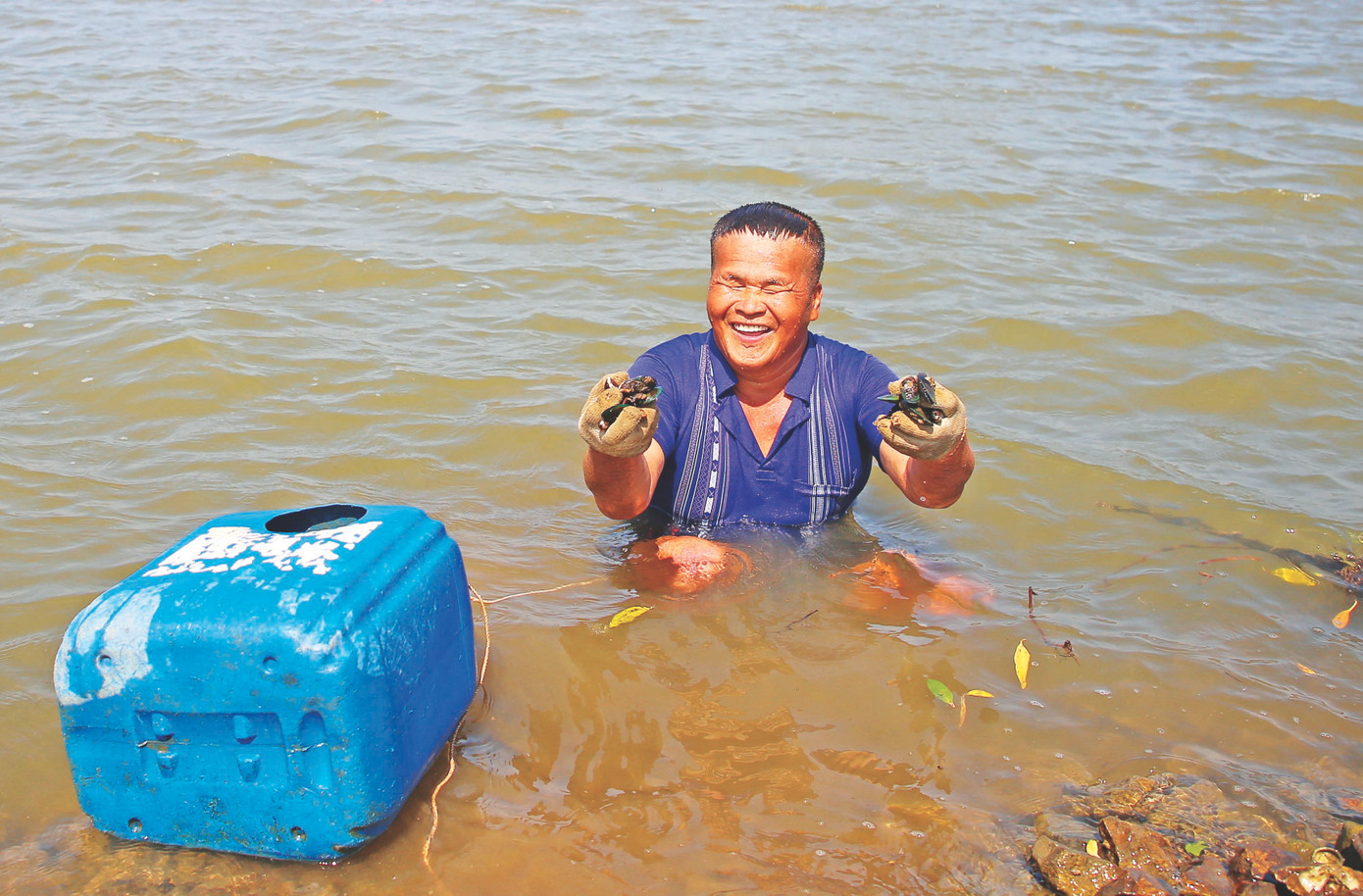Ông Chín Liều vui mừng khi lặn bắt được hải sản ở dưới biển