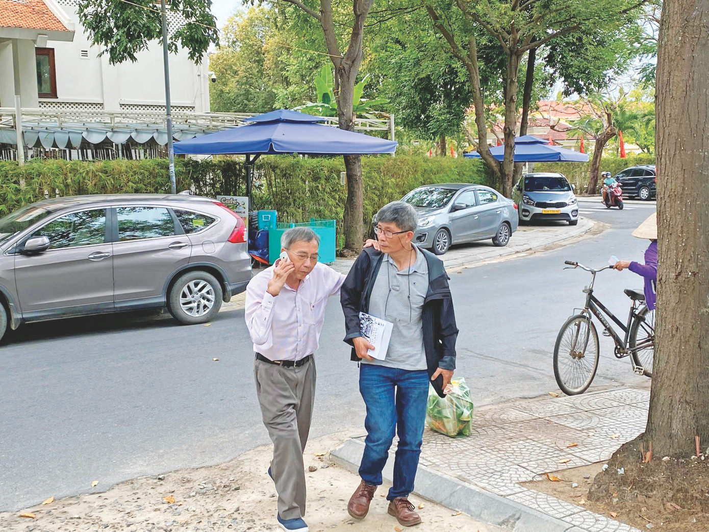 Nhà thơ Thanh Thảo với bước chân tập tễnh cùng tác giả một lần ở Hội An năm 2022. Ảnh: Phạm Đương