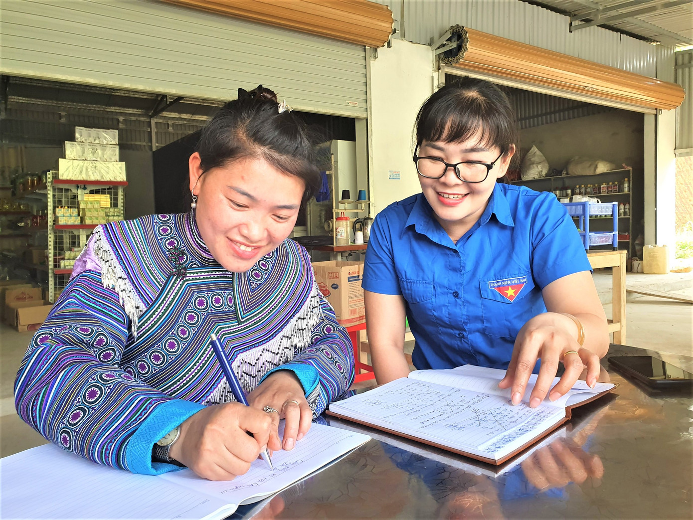 Bí thư Chi bộ Gia Khâu A Vàng Seo Dua (trái) làm sổ sách giúp người dân tại nhà. Bí thư Chi bộ Gia Khâu A Vàng Seo Dua (trái) làm sổ sách giúp người dân tại nhà.