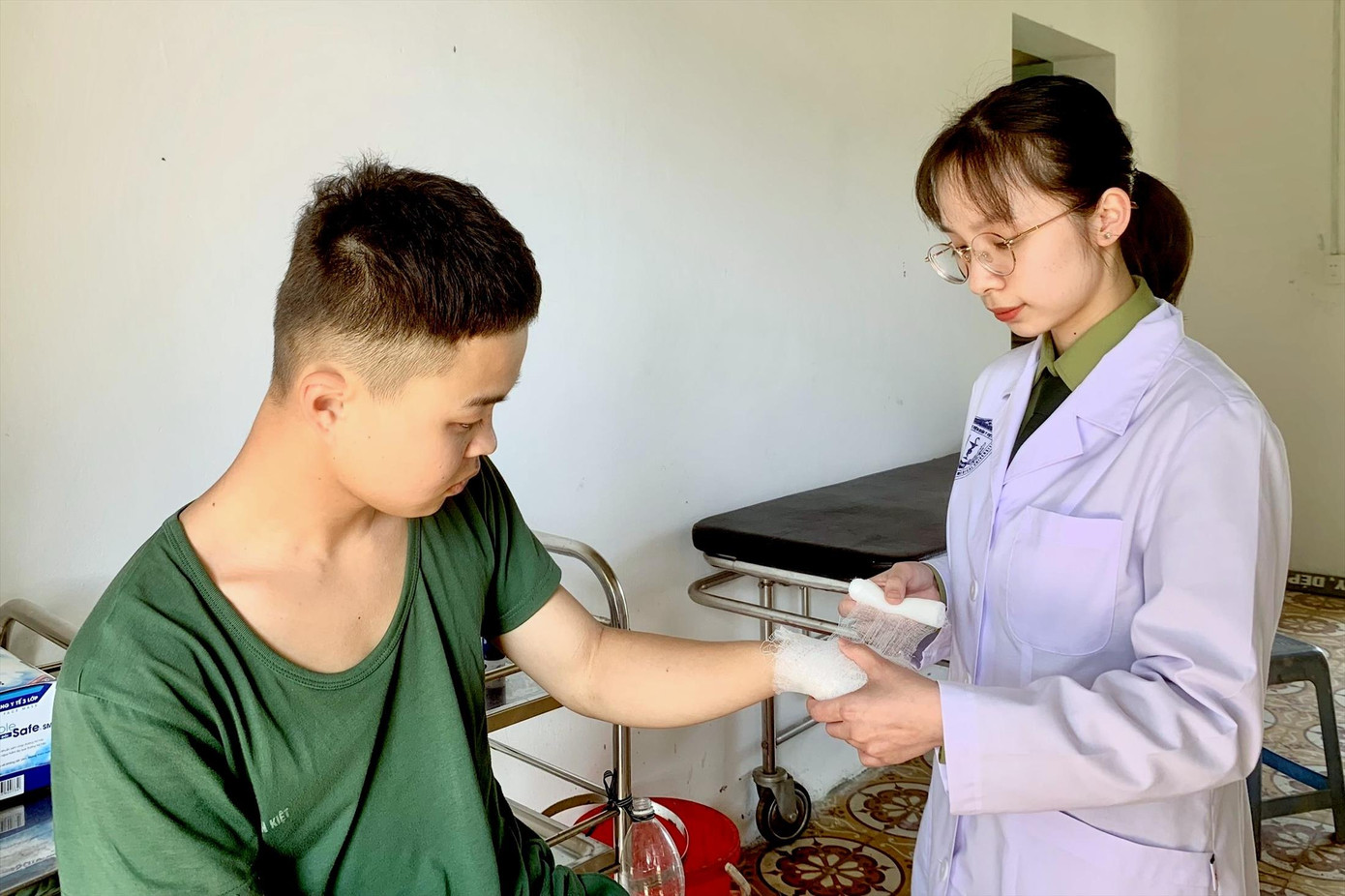 Thượng sĩ Nguyễn Thị Trang băng vết thương bàn tay cho một chiến sĩ tại Bệnh xá Trung đoàn 12, Sư đoàn 3 (Quân khu 1), trong thời gian thực tập tại đây, tháng 2/2023