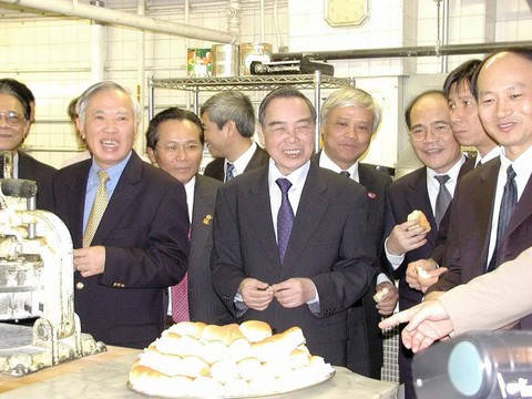 Thủ tướng Phan Văn Khải và thành viên trong đoàn Việt Nam đang nếm loại bánh trứ danh nơi anh Ba Nguyễn Tất Thành từng làm việc (6/2005)