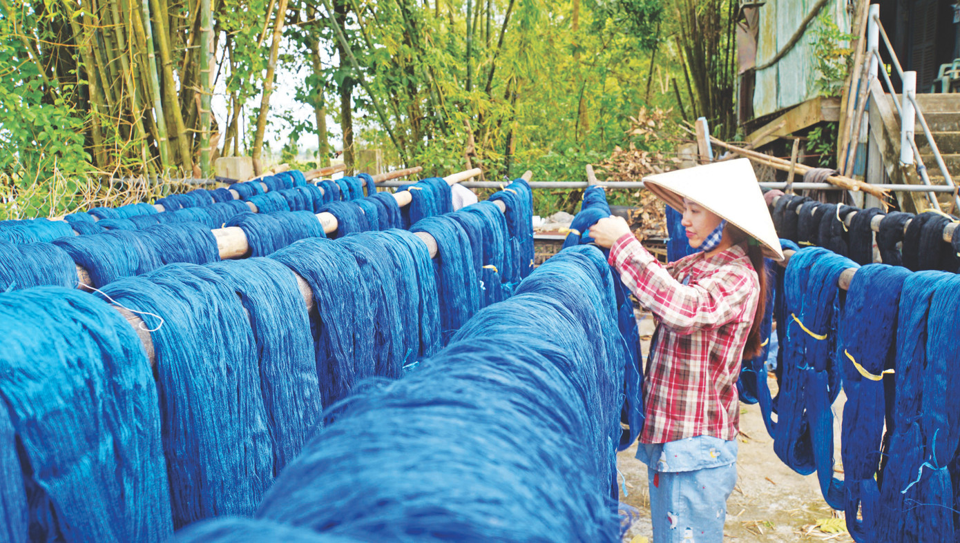 Người dân làng nghề dệt phơi chỉ ngoài sân