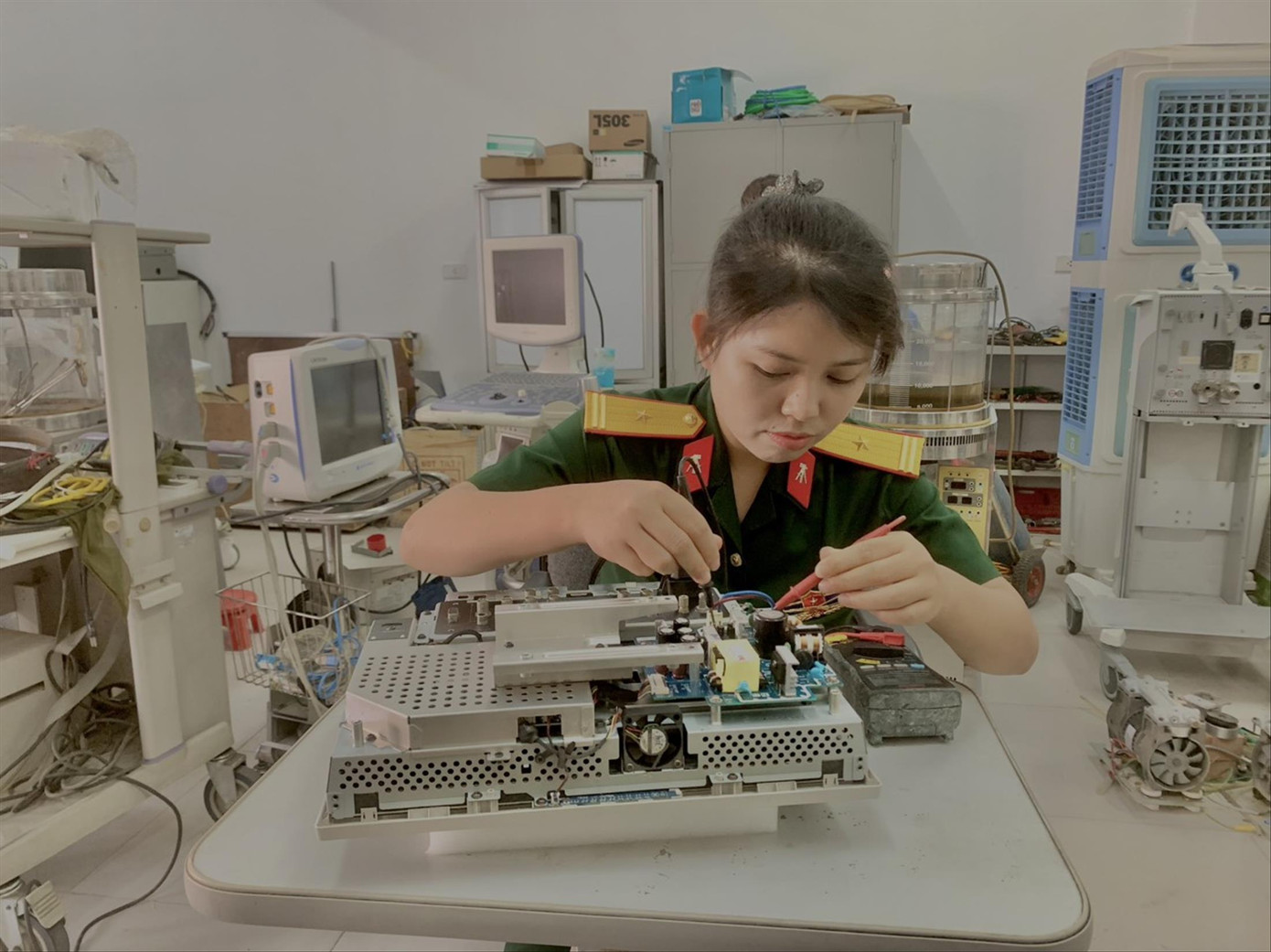 Thiếu tá Nguyễn Thị Tâm sửa chữa thiết bị y tế tại Bệnh viện Quân y 4. Ảnh: L.T.H