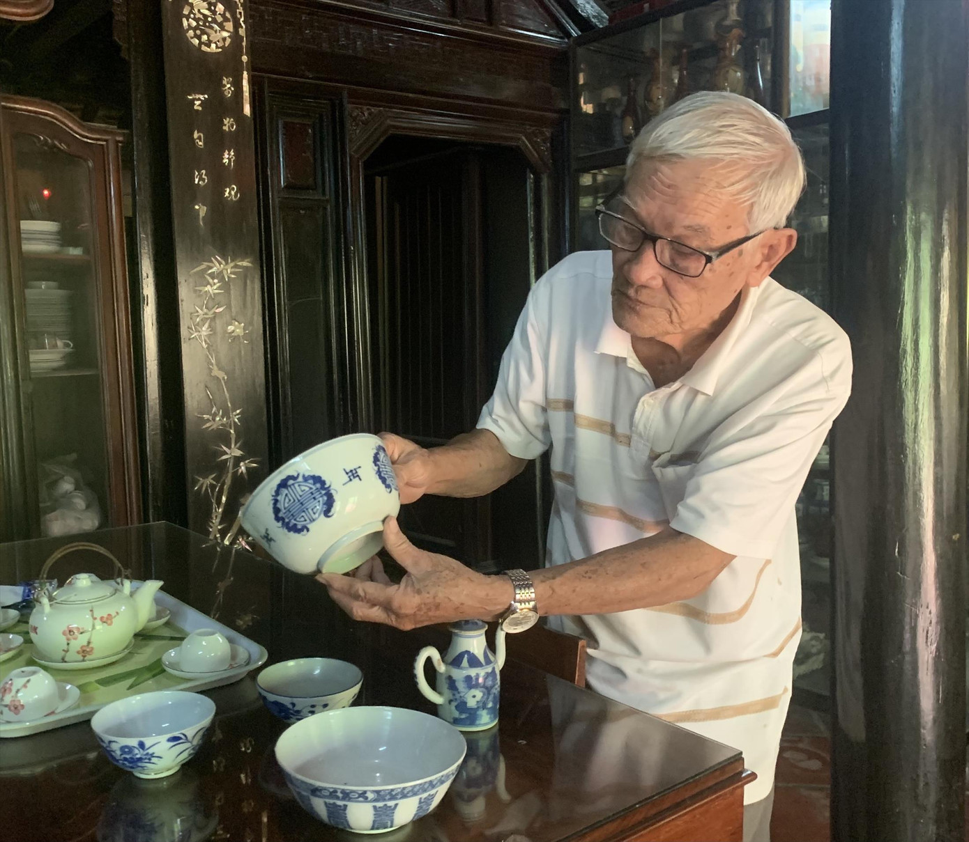 Ông Nguyễn Xuân Hải giới thiệu những món đồ cổ có tuổi đời hơn 200 năm được trưng bày trong nhà Ảnh: THỤC HIỀN