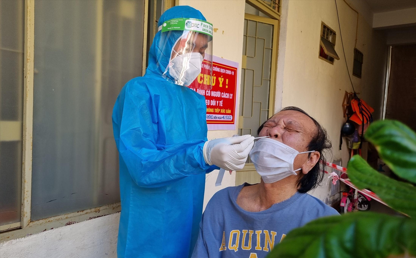 Nguyễn Xuân Vinh (sinh viên năm 4, Khoa Y, ĐH Duy Tân) lấy mẫu tại nhà cho F1 trên địa bàn phường Nại Hiên Đông (quận Sơn Trà). Ảnh: Thanh Trần