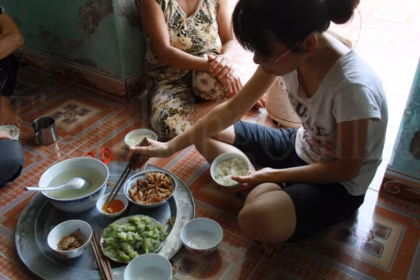 Bữa cơm của gia đình Hậu. Một bát tóp mỡ, một đĩa mướp luộc cùng một bát nước mắm. Bát thịt gần chục miếng là phần dành riêng cho bà nội. Ảnh: Trường Phong