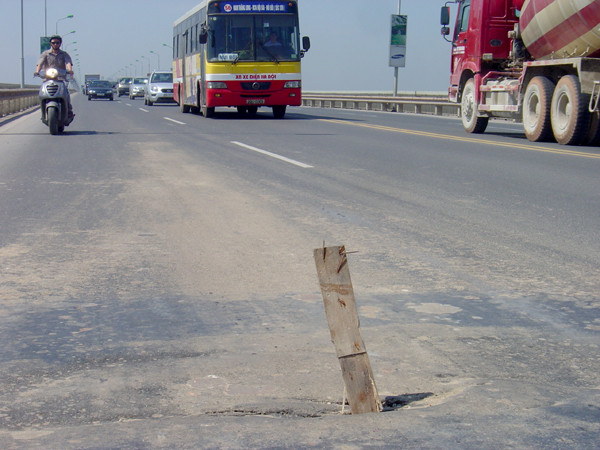 Người dân dùng thanh gỗ để cảnh báo cho các phương tiện qua lại