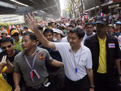 Lãnh đạo đảng Dân chủ, cựu Thủ tướng Abhisit Vejjajiva, vẫy tay trong lúc biểu tình cùng lực lượng chống chính phủ tại Bangkok hôm 9/12 Ảnh: Greg Baker