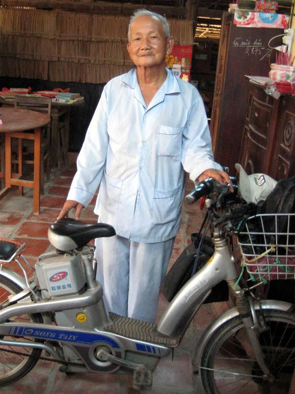 Ông Trần Ngọc Anh bên chiếc xe đạp điện hàng ngày đi dạy