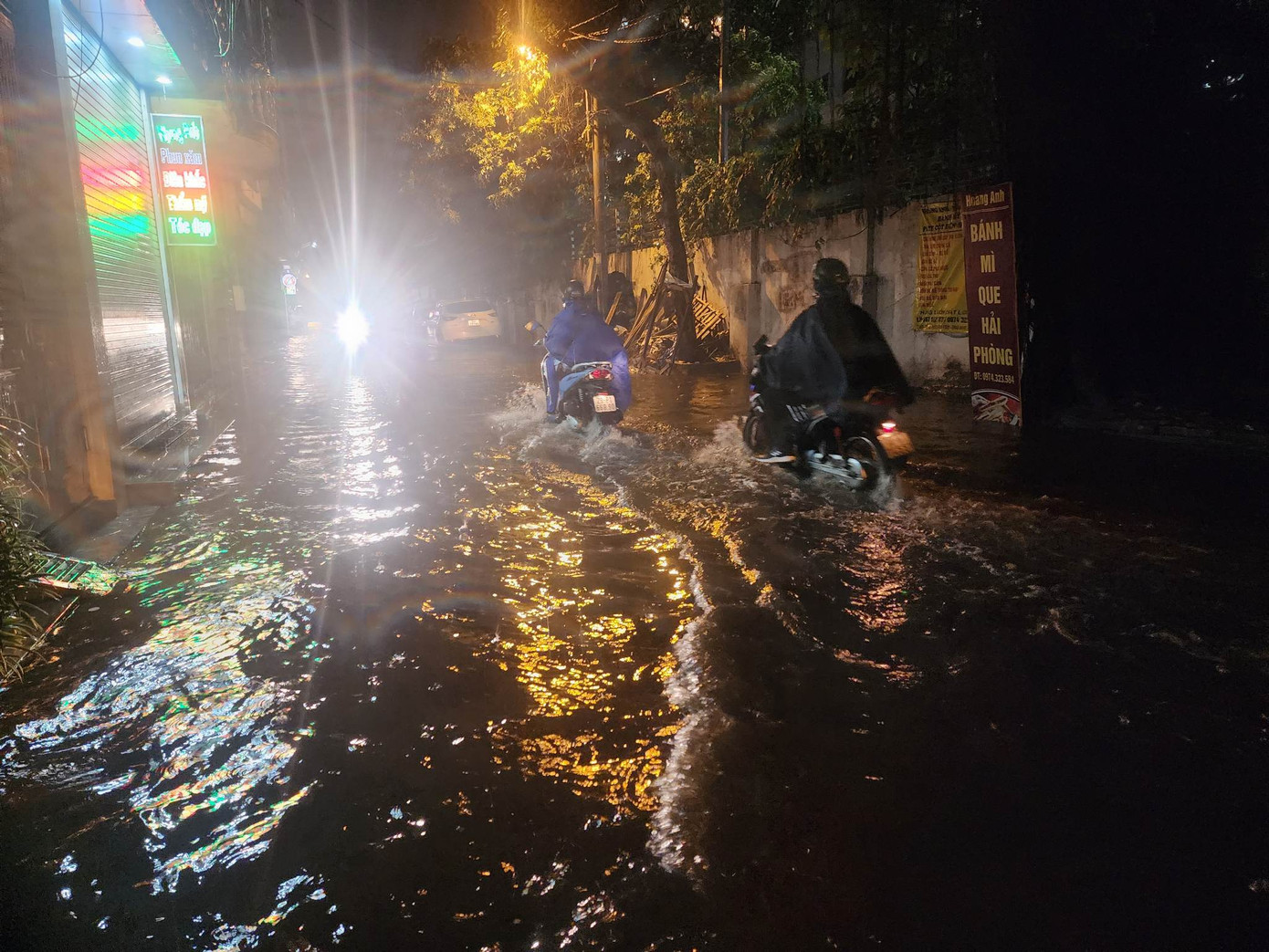 Nước ngập đến nửa bánh xe nên các phương tiện di chuyển trên phố Cự Lộc gặp khó khăn