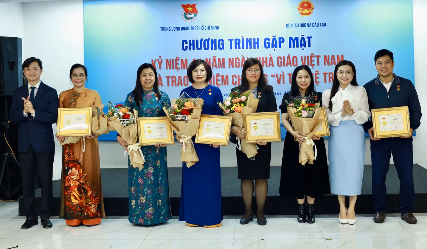 Chị Nguyễn Phạm Duy Trang, Bí thư T.Ư Đoàn, Chủ tịch Hội đồng Đội T.Ư và anh Nguyễn Minh Triết, Bí thư T.Ư Đoàn, Chủ tịch T.Ư Hội SVVN trao tặng Kỷ niệm chương Vì thế hệ trẻ cho cán bộ ngành Giáo dục. Ảnh: Bảo Anh