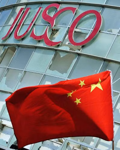 Hàng nghìn người Trung Quốc tụ tập biểu tình, đập phá các cơ sở kinh doanh của người Nhật ở Thanh Đảo, Sơn Đông. Cửa kính của siêu thị này bị ném vỡ tan. Phía bên dưới là quốc kỳ mà người sở tại mang theo trong cuộc biểu tình