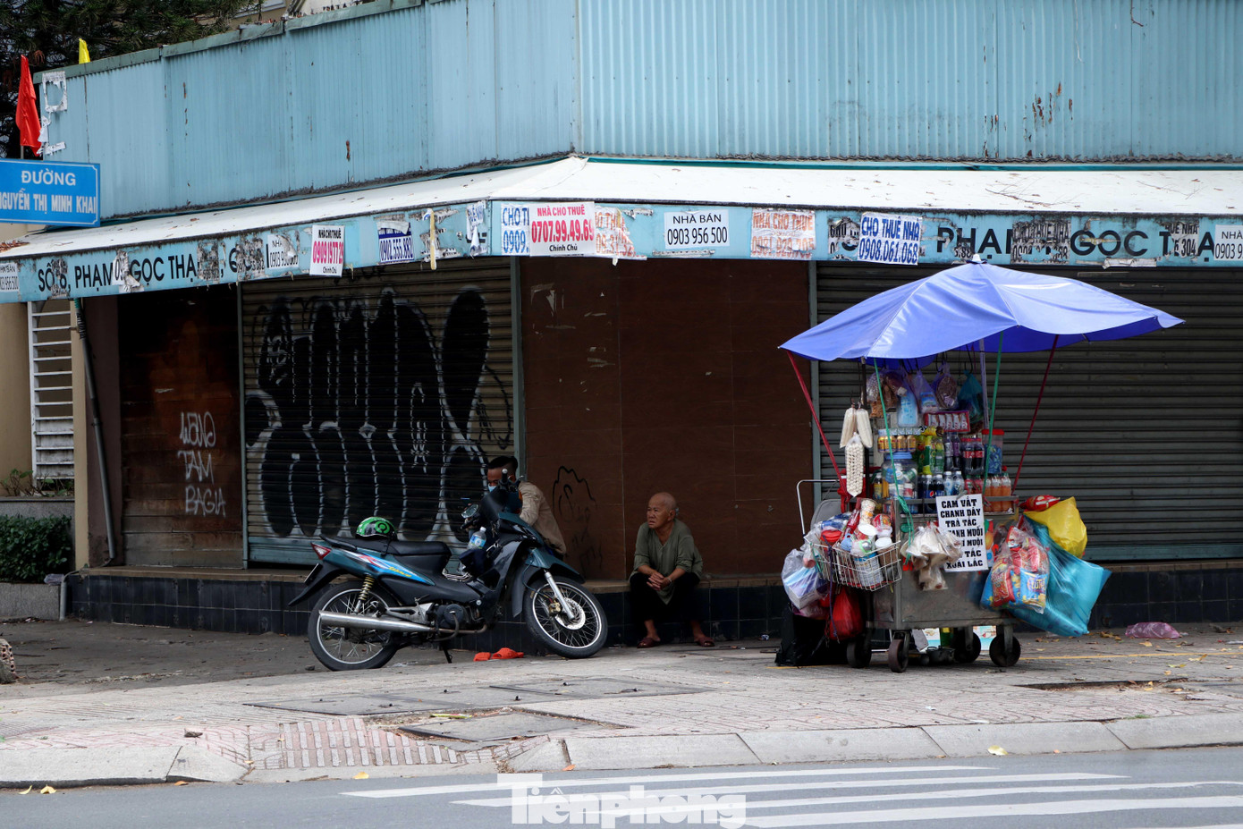 Giãn cách xã hội, người dân ít ra đường, cụ bà bán nước lề đường ngồi buồn vì cả buổi sáng không có khách.