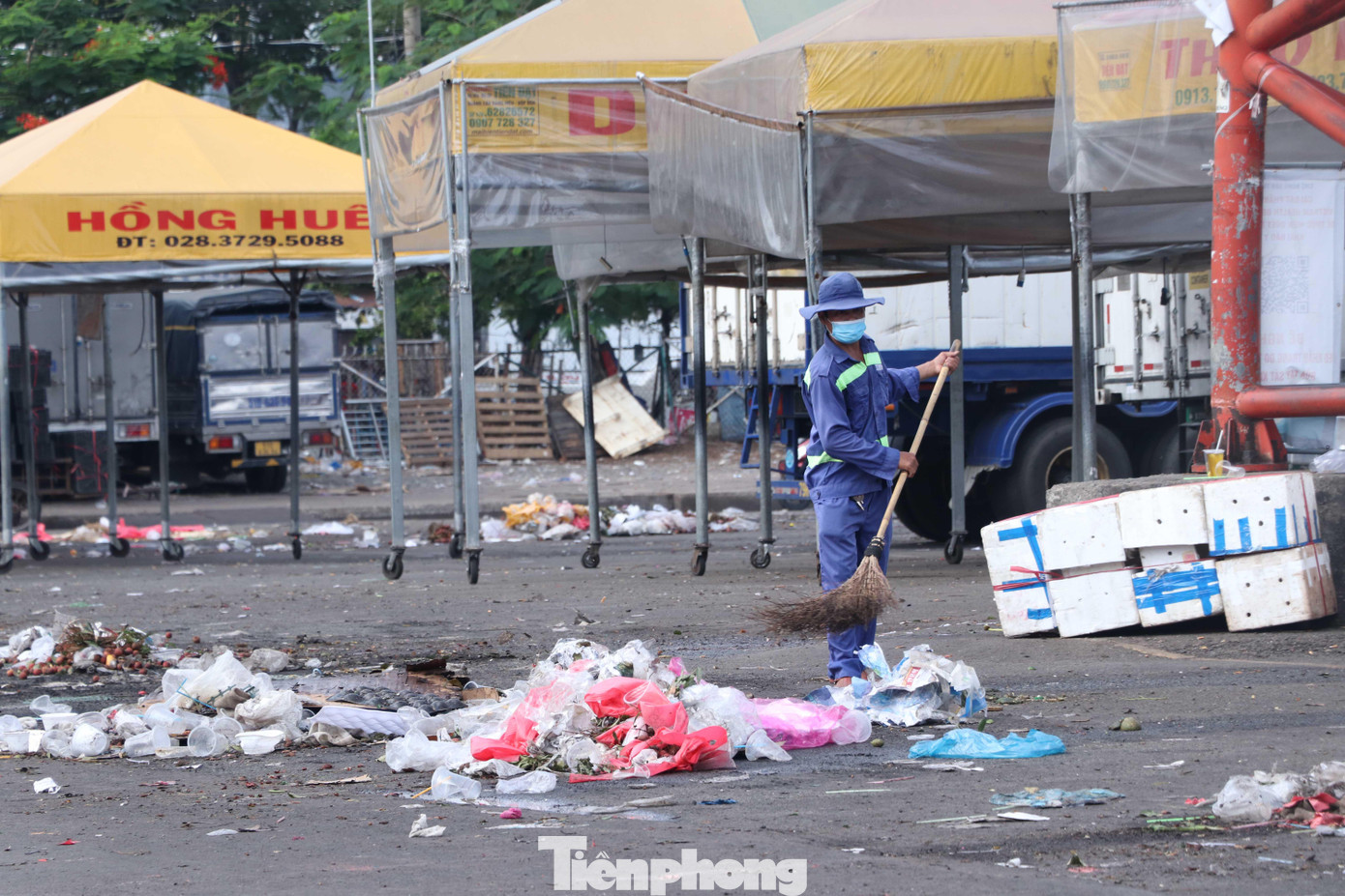 Nhân viên vệ sinh đang khẩn trương thu dọn rác thải sau buổi chợ cuối trước giờ tạm dừng hoạt động.