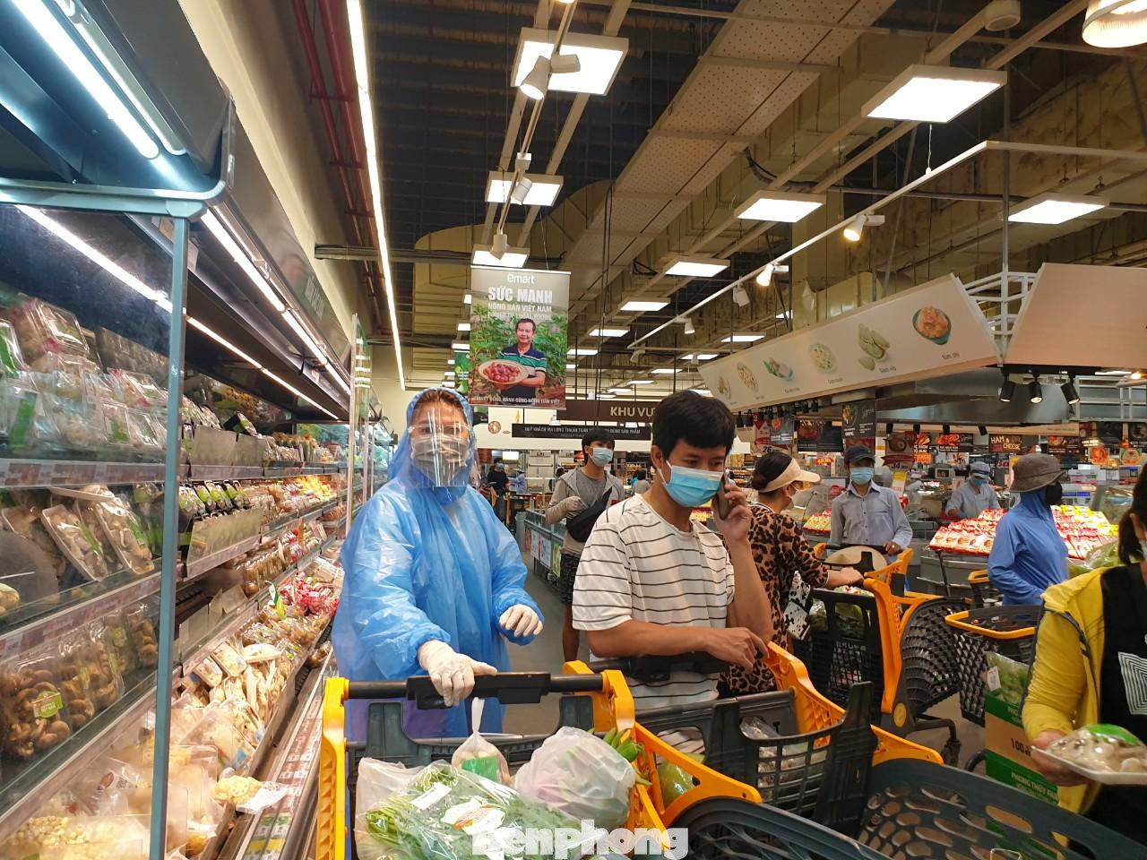 Một người phụ nữ trang bị đồ bảo hộ, kính chắn giọt bắn đi siêu thị để đảm bảo an toàn trong lúc dịch COVID-19 còn diễn biến phức tạp.