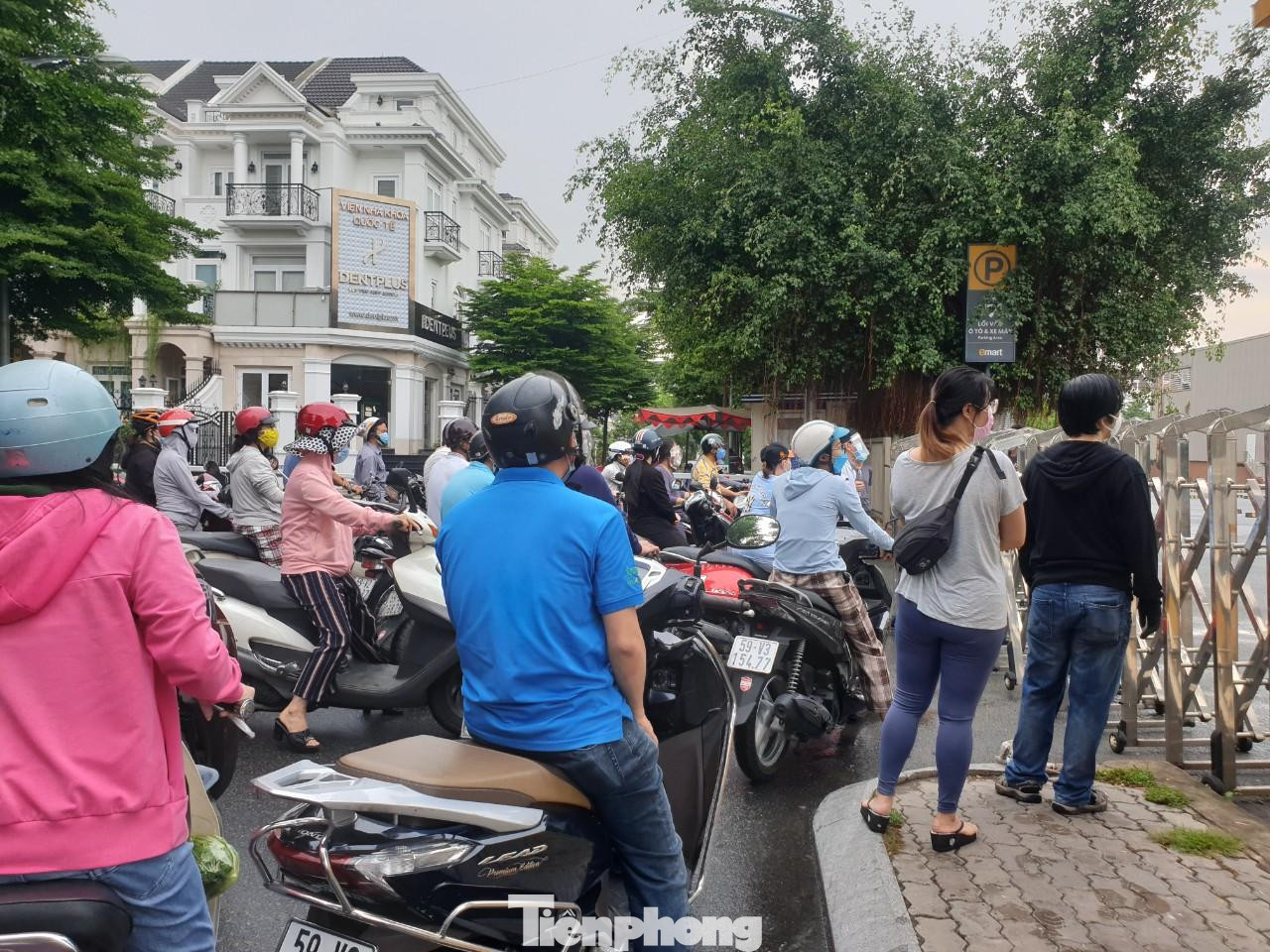Ghi nhận của phóng viên lúc 7h sáng, dù trời có mưa nhỏ nhưng người dân vẫn kiên nhẫn đứng trước cổng siêu thị để đợi đến lượt vào mua hàng.