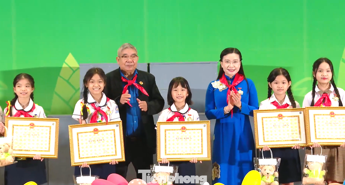 Chị Nguyễn Phạm Duy Trang và ông Nguyễn Văn Thỏa - nguyên Bí thư Tỉnh Đoàn Sông Bé trao tặng bằng khen cho các gương Cháu ngoan Bác Hồ.