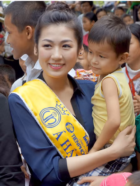 A hậu Dương Tú Anh, bồng một em bé tại Trường mầm non Tam Văn (Xã Tam Văn huyện Lanh Chánh)