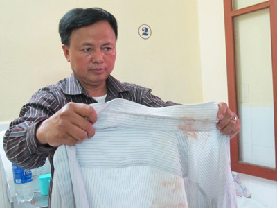 Ông Khương cho phóng viên xem chiếc áo anh Khánh có nhiều vết máu. Ông Khương cho phóng viên xem chiếc áo anh Khánh có nhiều vết máu