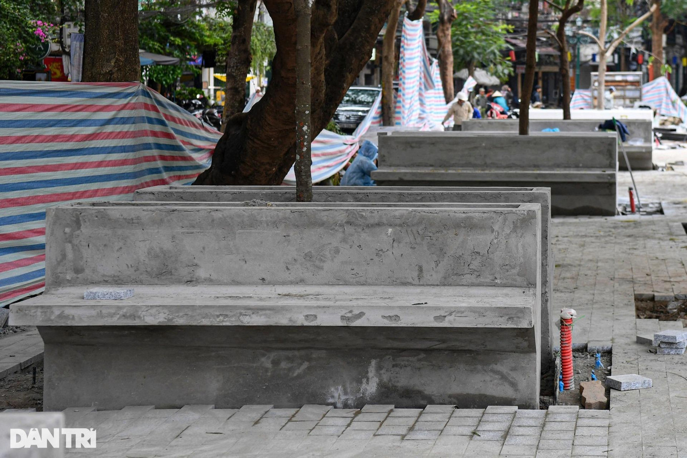 Loạt ghế đá trong khuôn viên phố đi bộ về cơ bản đã xong phần thô và đang được công nhân lát đá.