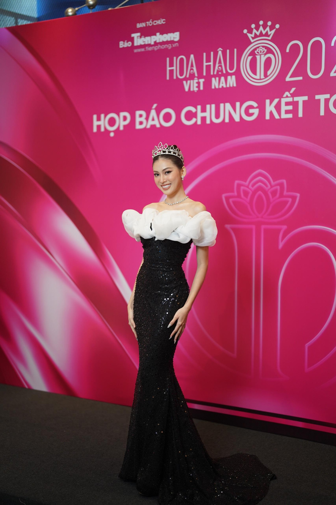 Á hậu Ngọc Thảo diện váy dạ hội kiểu đuôi cá, kết hợp hai tông màu trắng - đen sang trọng. Điểm nhấn của thiết kế là phần bèo nhún giúp người đẹp khoe vai trần quyến rũ.