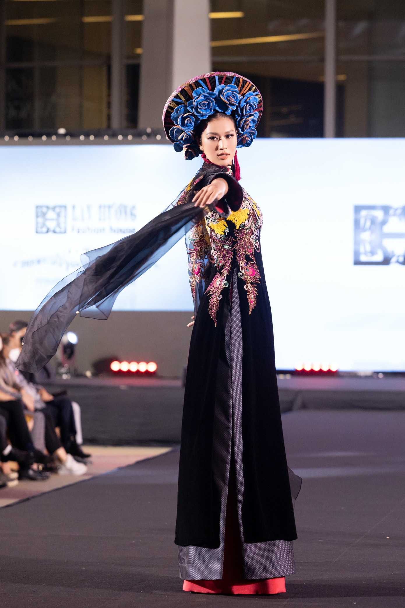 Miss Grand Việt Nam, top 20 Miss Grand International 2022 Đoàn Thiên Ân cũng góp mặt trong một màn trình diễn với vai trò vedette. Cô diện bộ áo dài màu đen với phần tà xuyên thấu bay bổng.