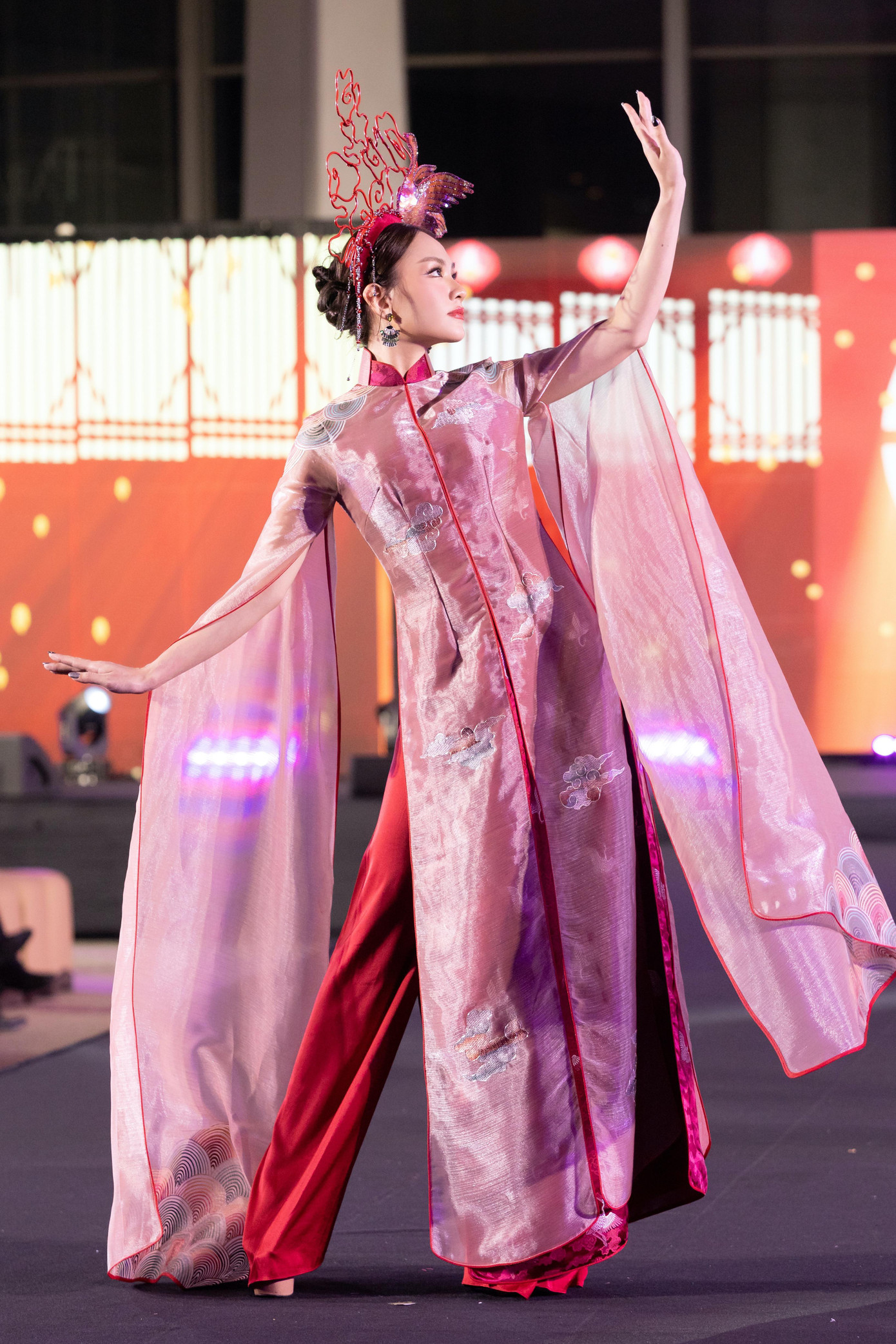Miss World Việt Nam 2022 Huỳnh Nguyễn Mai Phương đảm nhận vai trò vedette khi trình diễn trong bộ sưu tập áo dài lấy cảm hứng về tiên hạc. Điểm nhấn của thiết kế là chiếc mũ với hình đôi chim hạc được tạo hình kỳ công, ấn tượng.