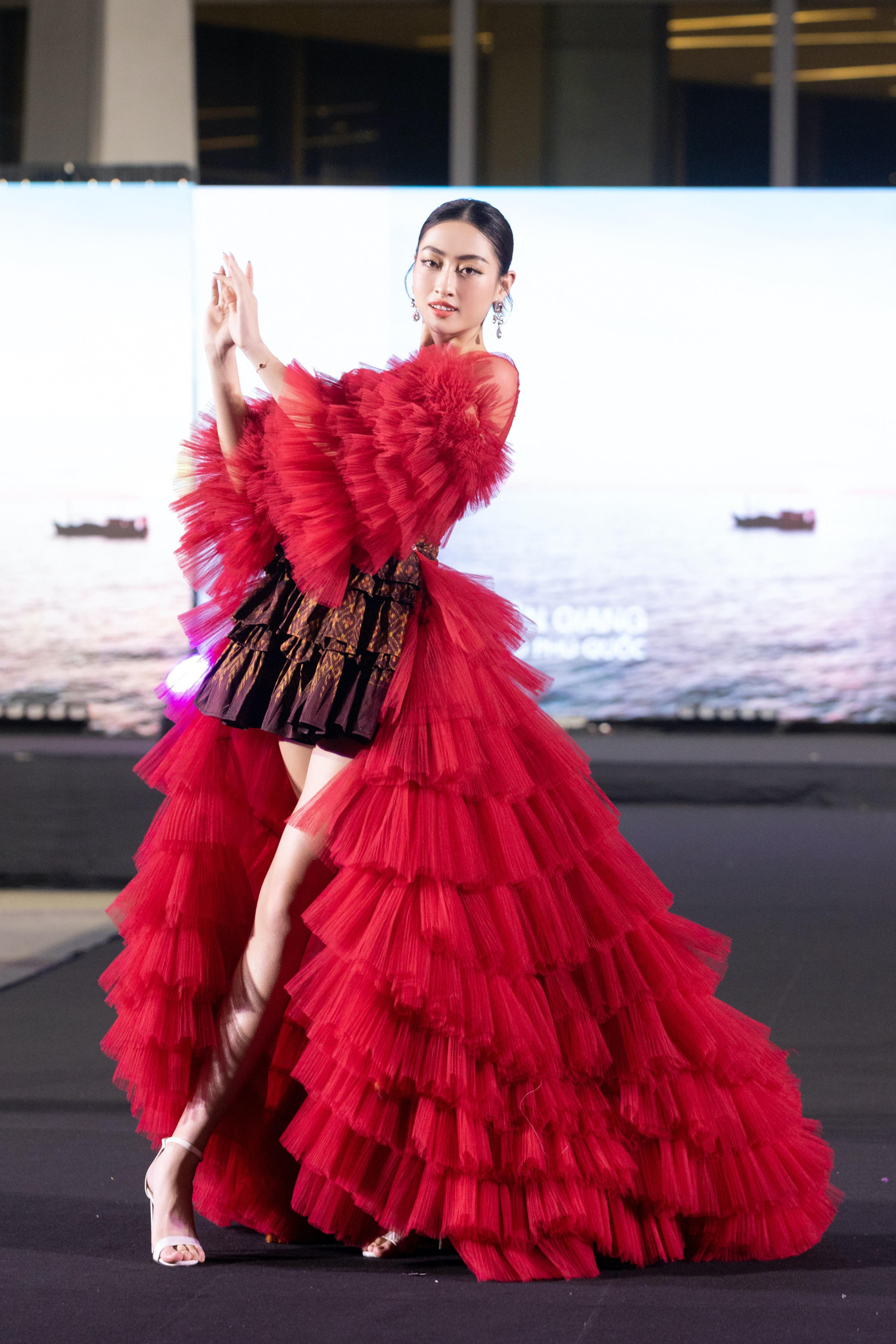 Khác với các người đẹp khác, Lương Thùy Linh không trình diễn áo dài. Cô diện thiết kế xếp ly độc đáo, khoe đôi chân dài quyến rũ trên sàn catwalk.