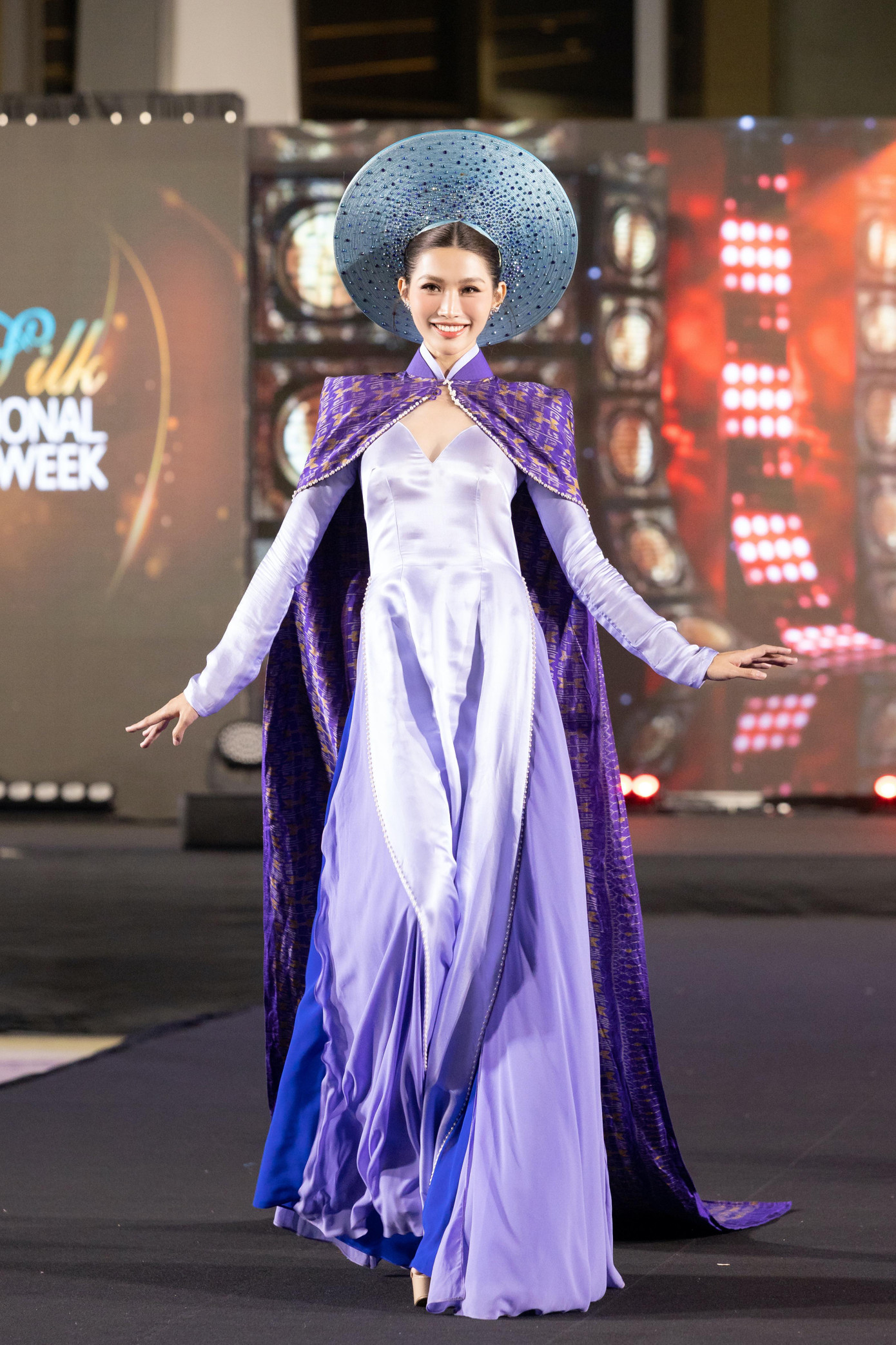 Á hậu Quỳnh Châu xuất hiện với vai trò first face trong một màn trình diễn. Cô diện áo dài màu tím kết hợp phần áo choàng lộng lẫy.