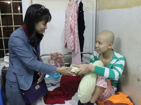 Cô giáo Trần Thị Nhung trao những hộp sữa cho em gái bị ung thư tại Bệnh viện K