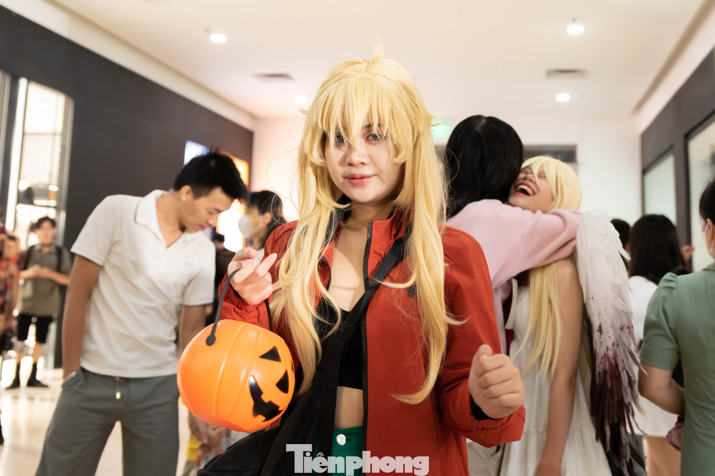 Một bạn nữ lấy trái bí ngô khoét lỗ, biểu tượng của lễ Halloween làm đạo cụ.