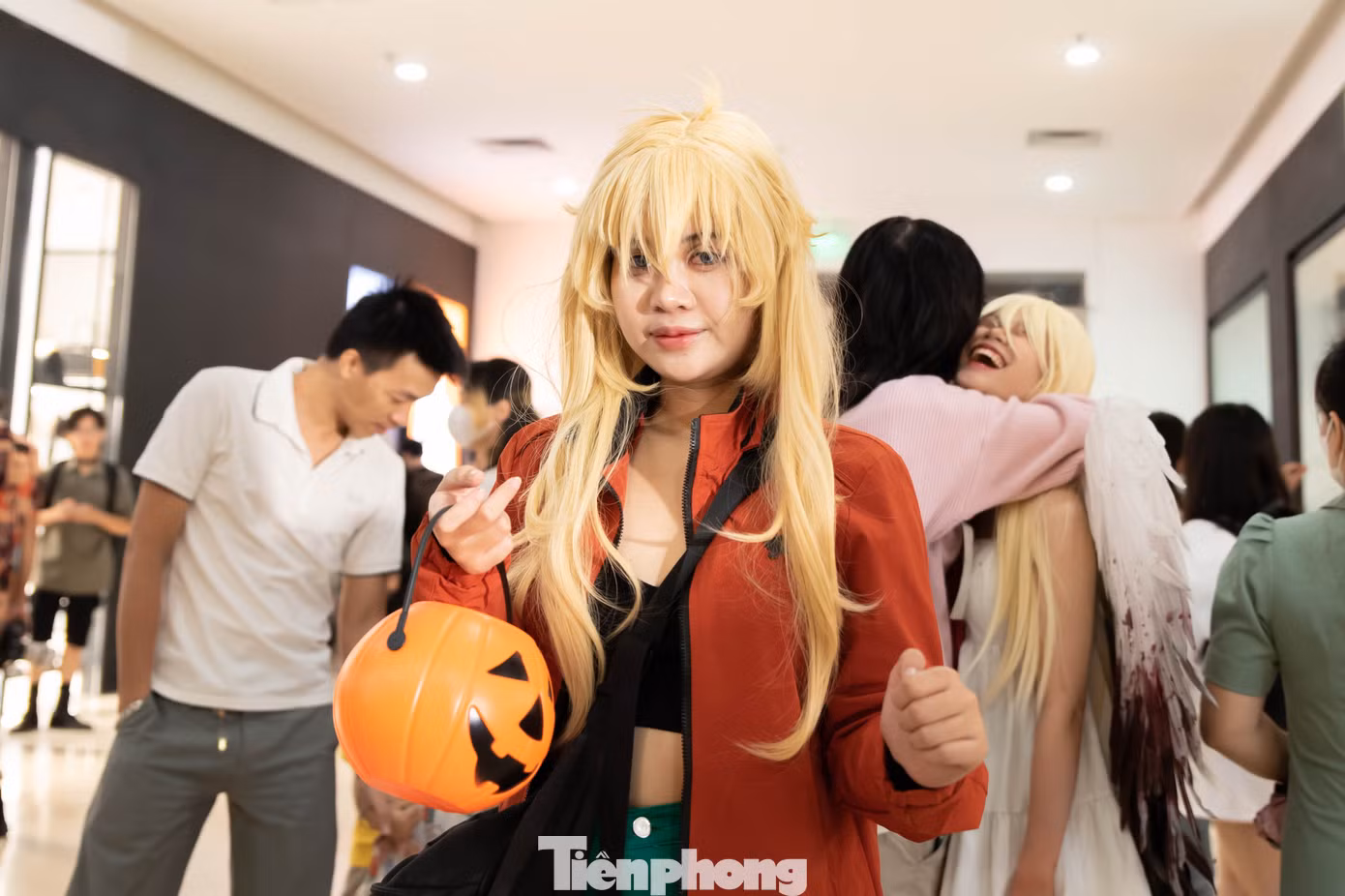 Một bạn nữ lấy trái bí ngô khoét lỗ, biểu tượng của lễ Halloween làm đạo cụ.