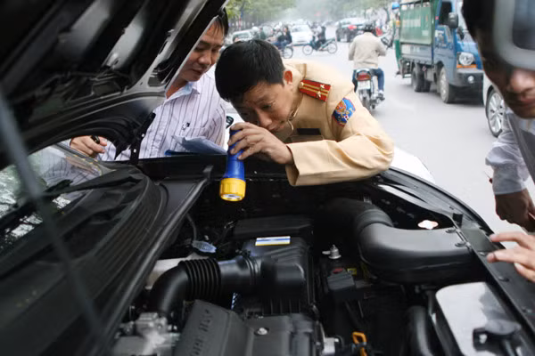 Cảnh sát giao thông kiểm tra, làm thủ tục đăng ký cấp biển kiểm soát cho người dân. Cảnh sát giao thông kiểm tra số khung cố máy và làm thủ tục đăng ký cấp biển kiểm soát cho người dân