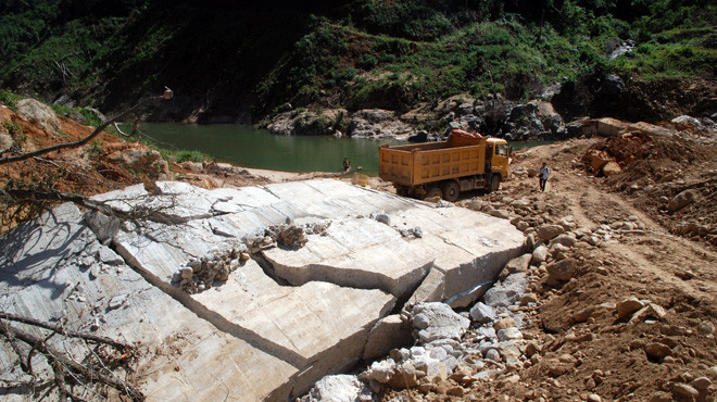 Đập phía thượng lưu của thủy điện Đăk Mek 3 bị vỡ và chiếc xe ben được cho là thủ phạm (ảnh chụp chiều 25-11). Ảnh: hữu khá