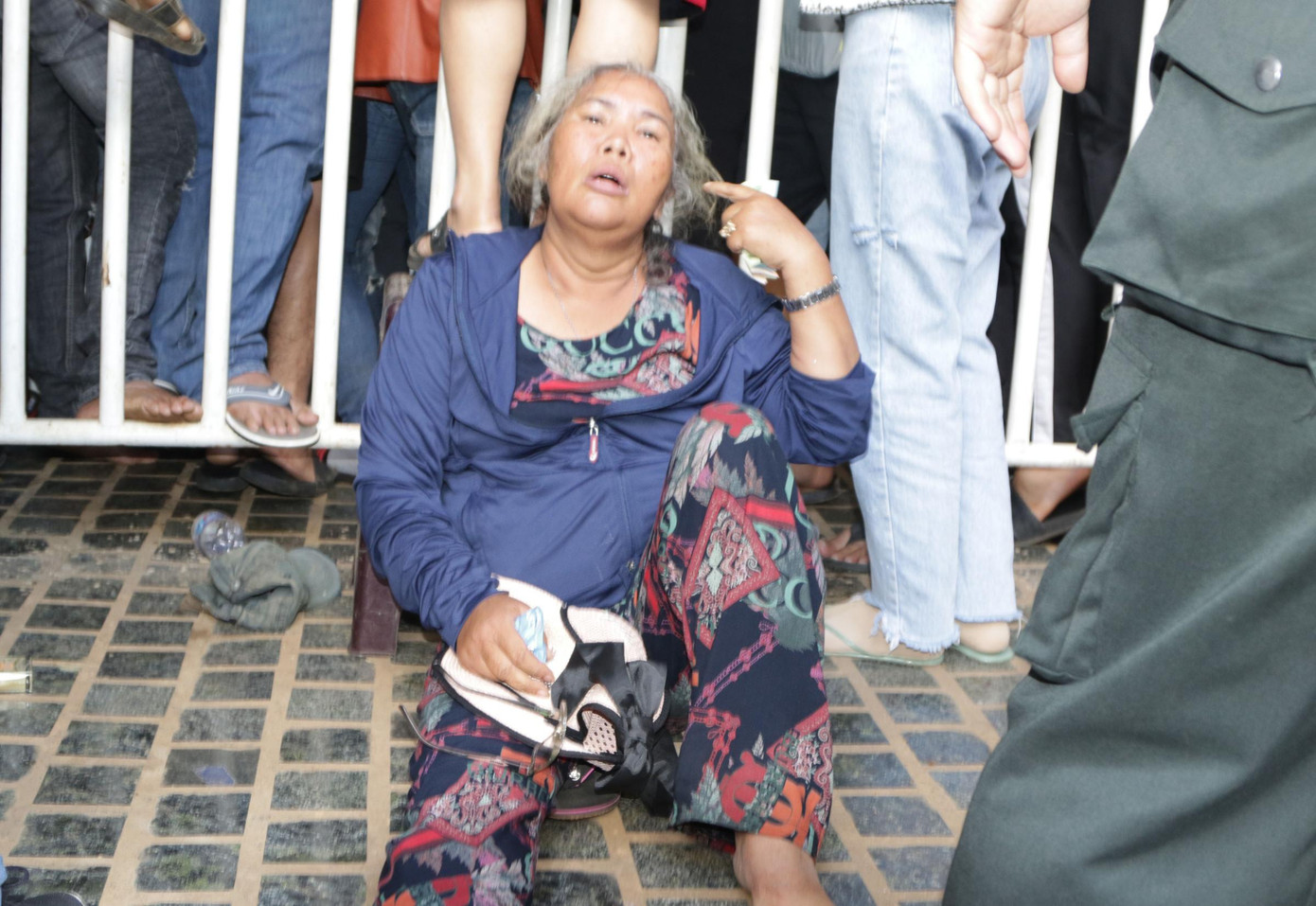 Có người vì chen lấn quá mệt phải ra ngoài ngồi thở sau khi đã mua được một số vé.